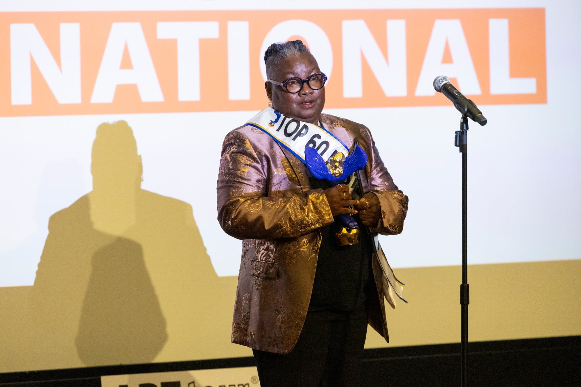 A 2024 honoree speaks on stage holding the award