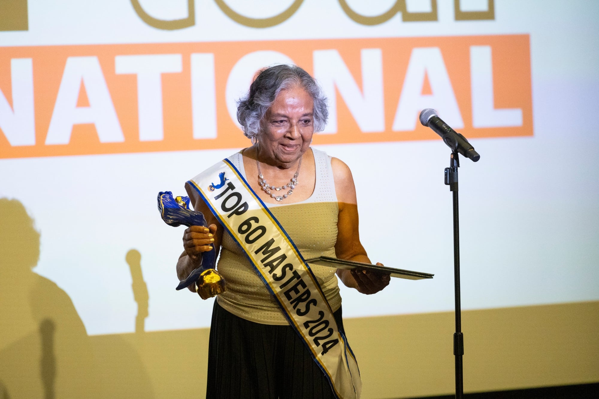 A 2024 honoree on stage with the award and certificate