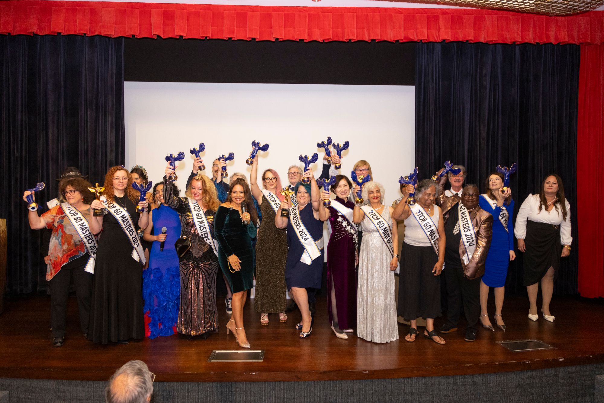 2024 Top 60 Masters honorees on stage raising their awards
