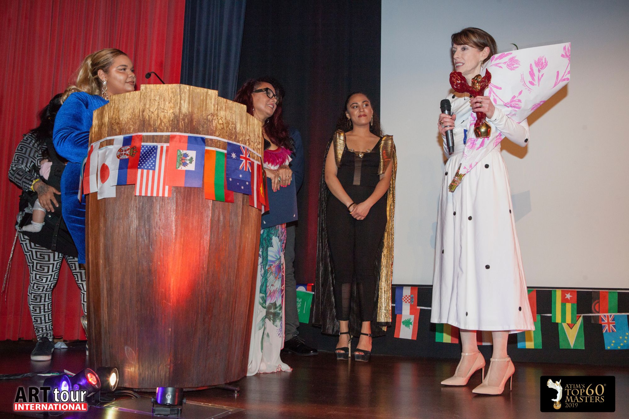 An honoree gives an acceptance speech with the award and flowers
