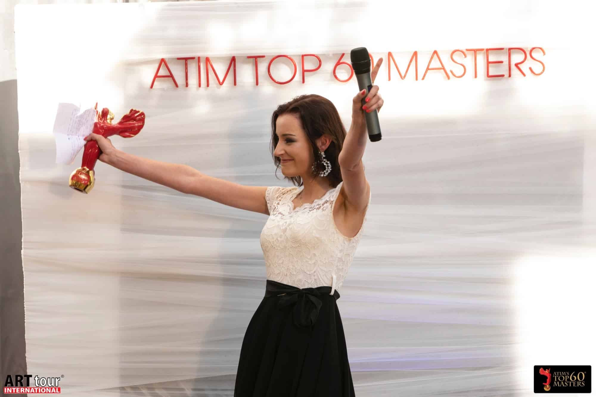An honoree celebrates on stage with the award